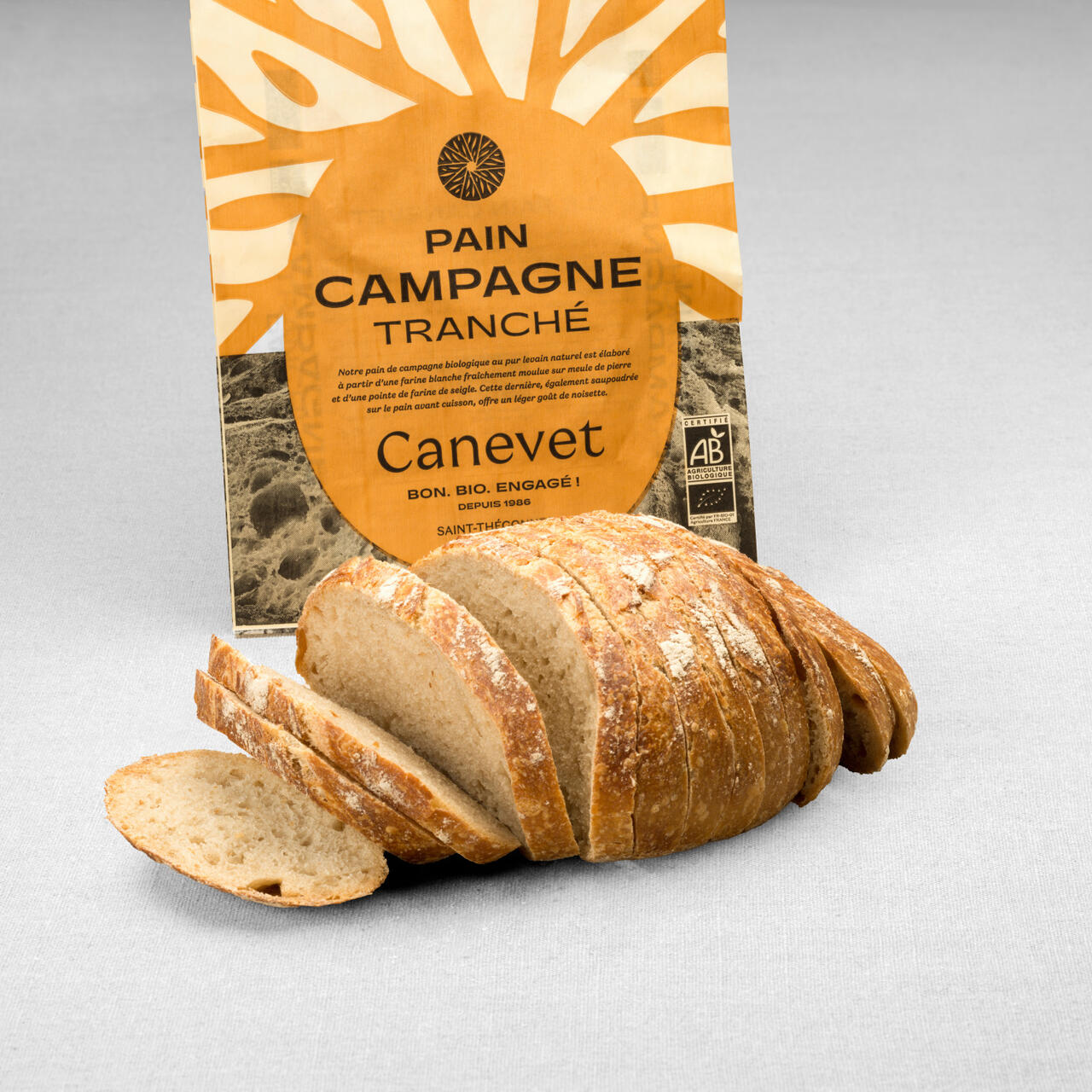 Pain campagne au pur levain naturel tranché avec packaging en arrière plan