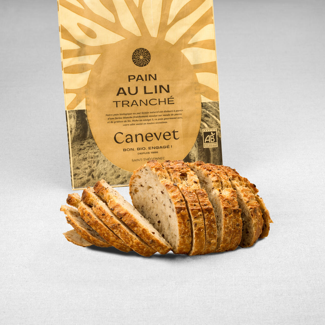 Pain aux graines de lin  au pur levain naturel tranché avec packaging en arrière plan