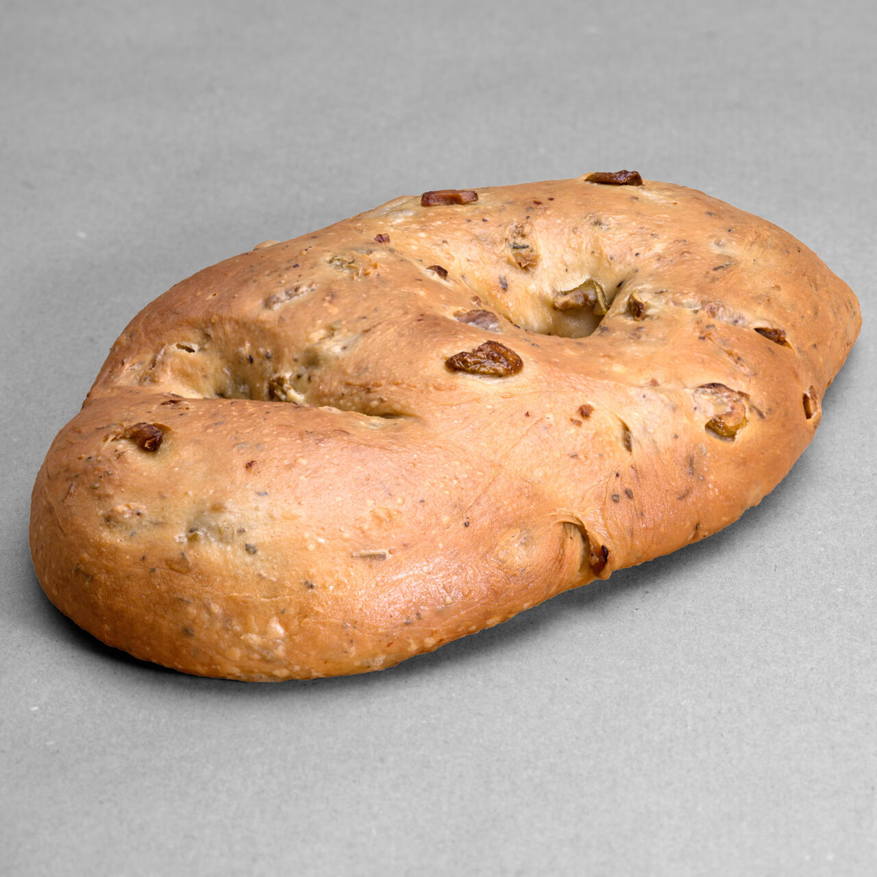 Fougasse olives vertes et herbes de Provence posée sur un fond gris