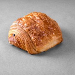 Pain au chocolat posé sur un fond gris