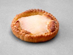 Tartelette aux poires et aux amandes posée sur un fond gris