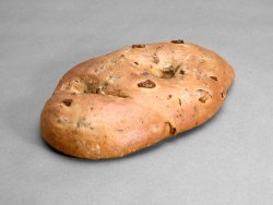 Fougasse olives vertes et herbes de Provence posée sur un fond gris