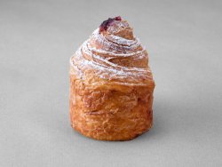 Cruffin aux myrtilles posé sur un fond gris