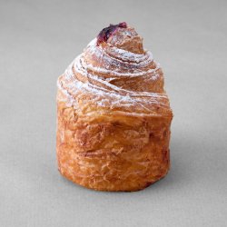 Cruffin aux myrtilles posé sur un fond gris